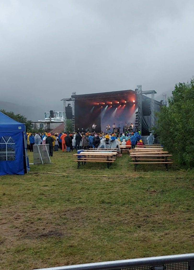 Oversiktsbilde av Høllafestivalen 2022 hvor været ikke var så bra. Brenn. spiller på hovedscenen.